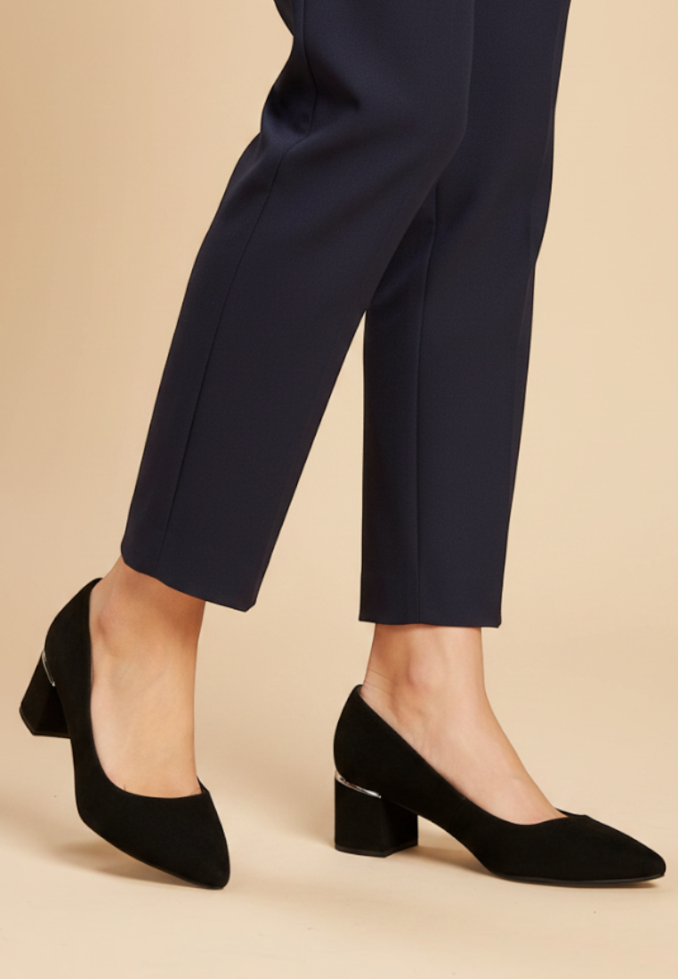 Falio black faux suede block heel pumps with a 6 cm heel worn with navy trousers on a neutral background