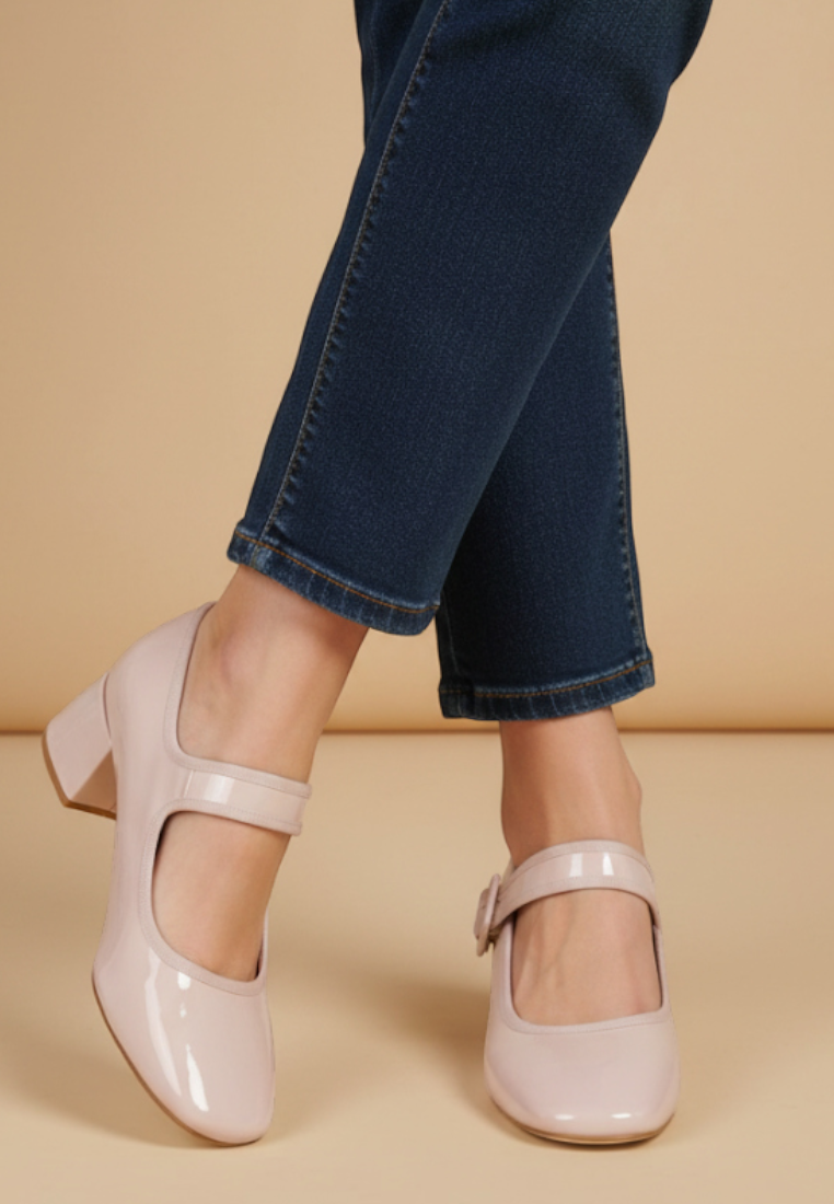 Falio beige faux leather block heel pumps with round toe and buckle strap worn with dark blue jeans