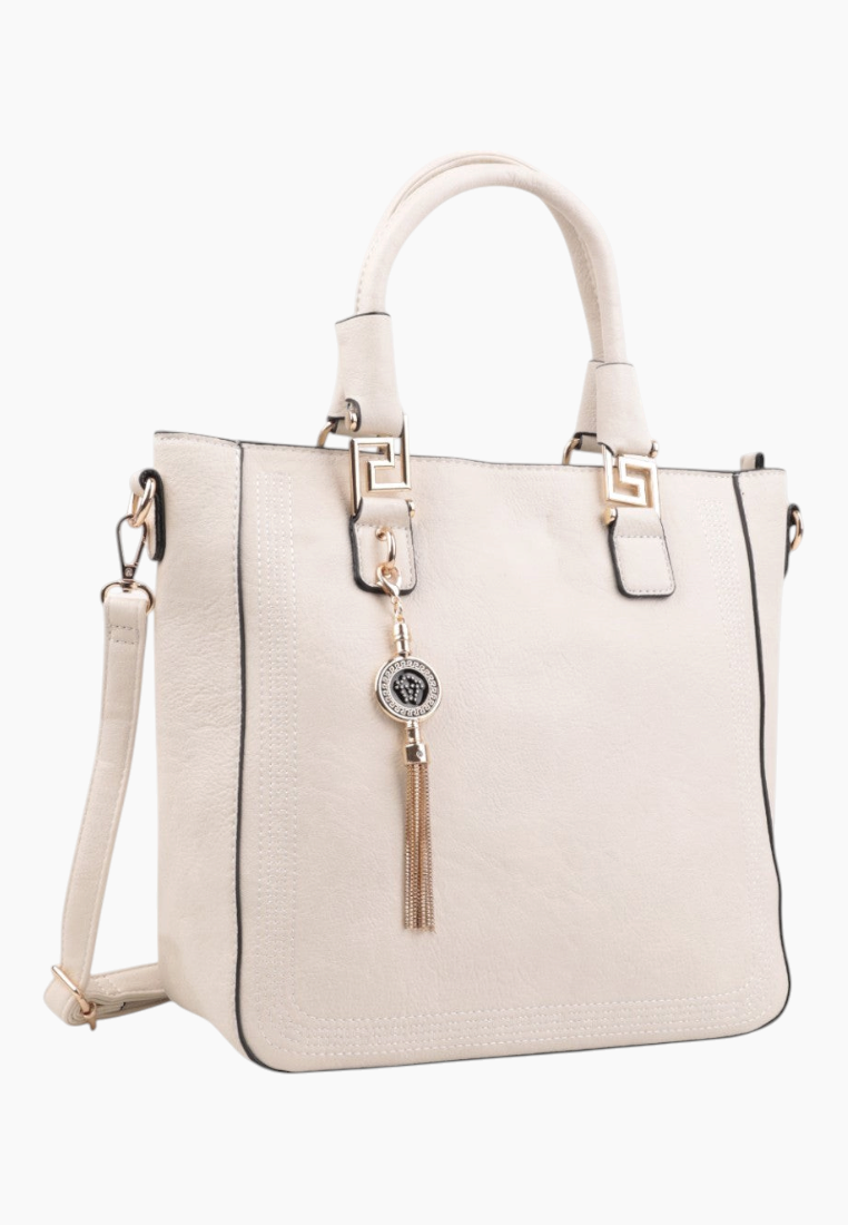 Front view of a cream handbag with zipper closure and tassel charm.