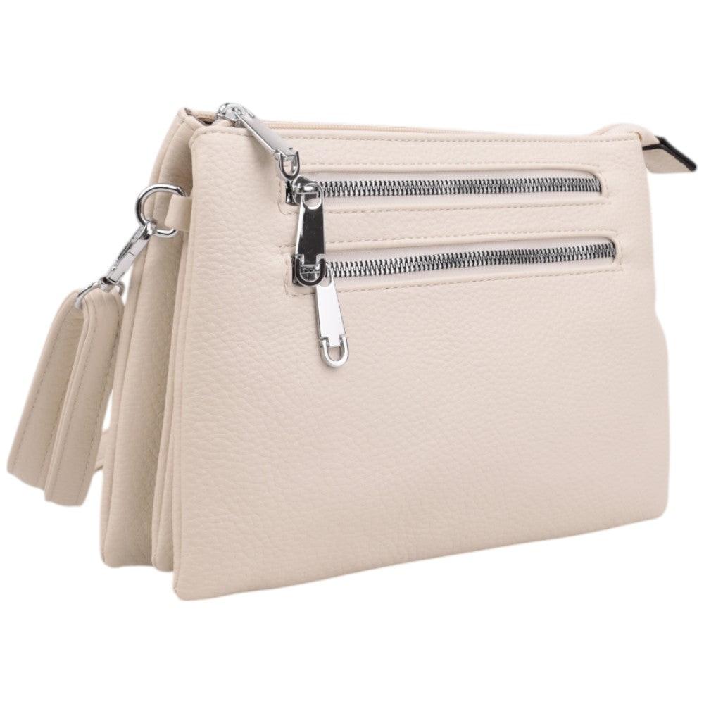 Detail view of the beige clutch bag showing two zippered pockets and tassel detail.