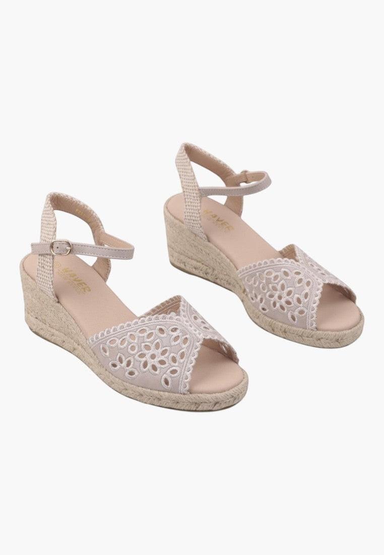 Side view of beige wedge sandals with ankle strap on a white background