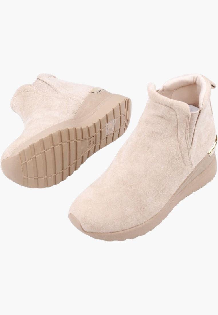 Detal beżowych botków sneakersów z miękkiego materiału na białym tle.
