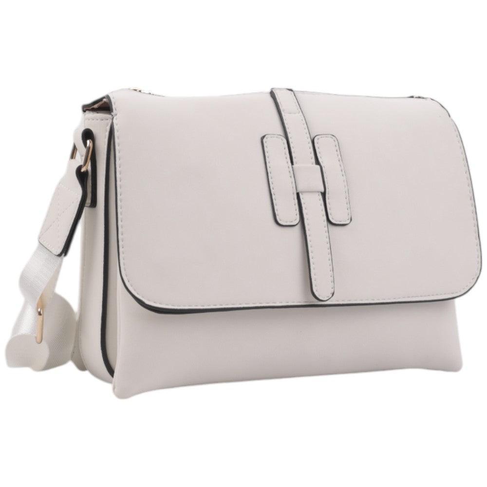 Front view of a light gray handbag with flap closure and adjustable strap on a white background.