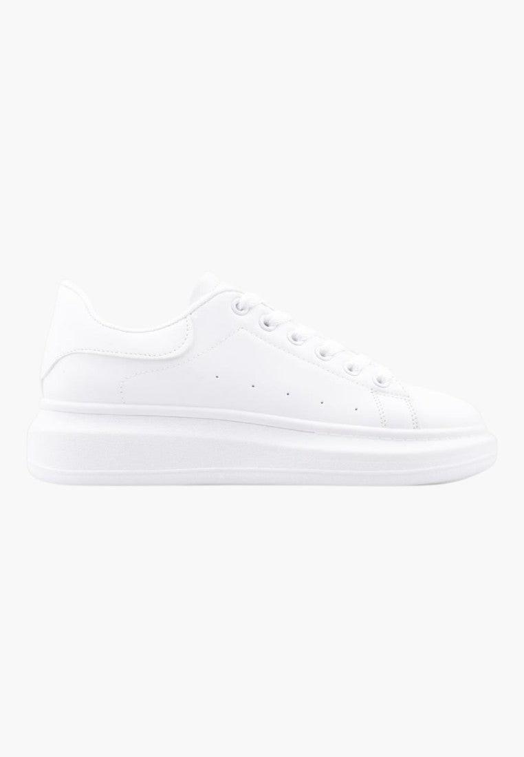 Białe minimalistyczne sneakersy widok z boku, elegancki styl.