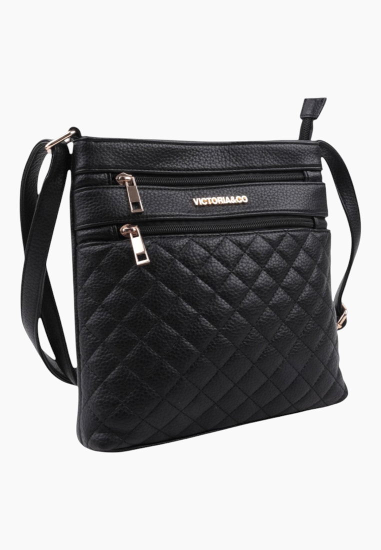Detail of the black quilted handbag showcasing zipper closure and gold hardware.