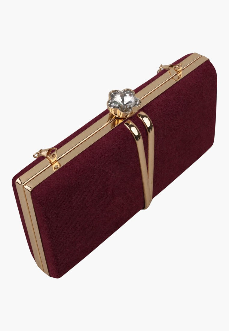 Side view of a burgundy clutch bag featuring a gold clasp on a white background