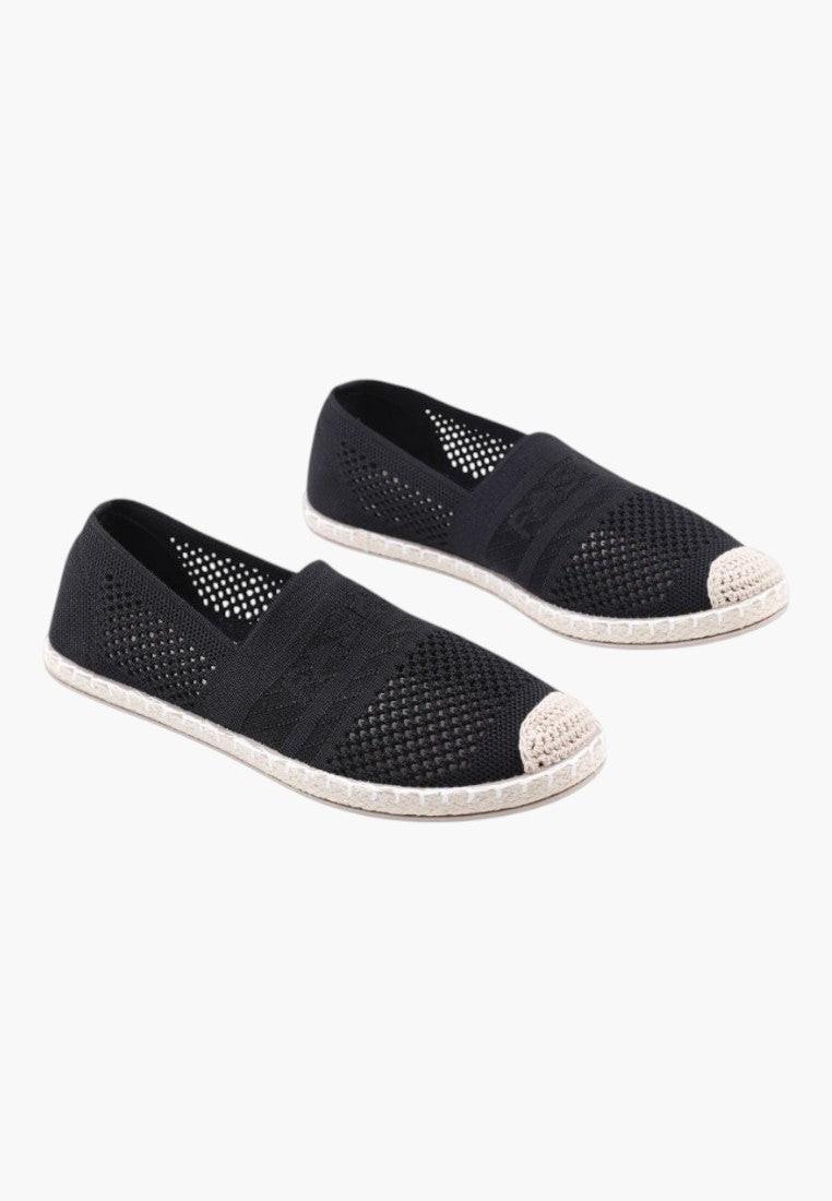 Front view of black slip-on shoes with a minimalist design on a white background.