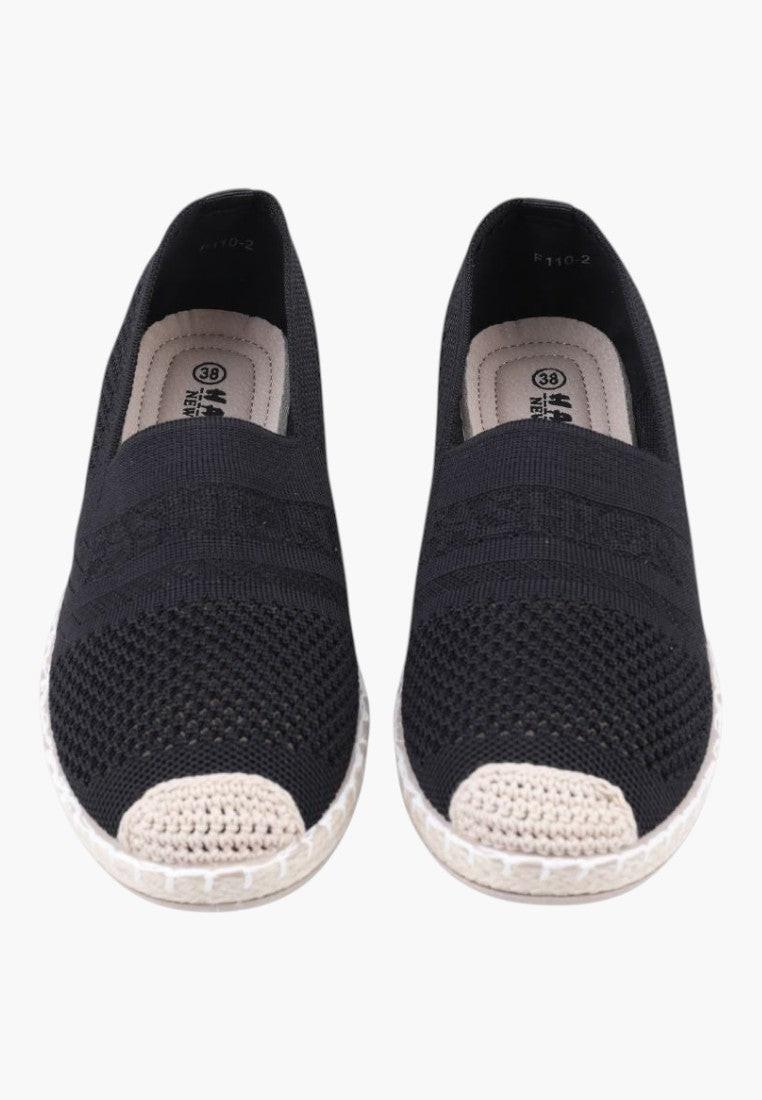 Top view of black slip-on shoes featuring elastic sides and textured fabric.