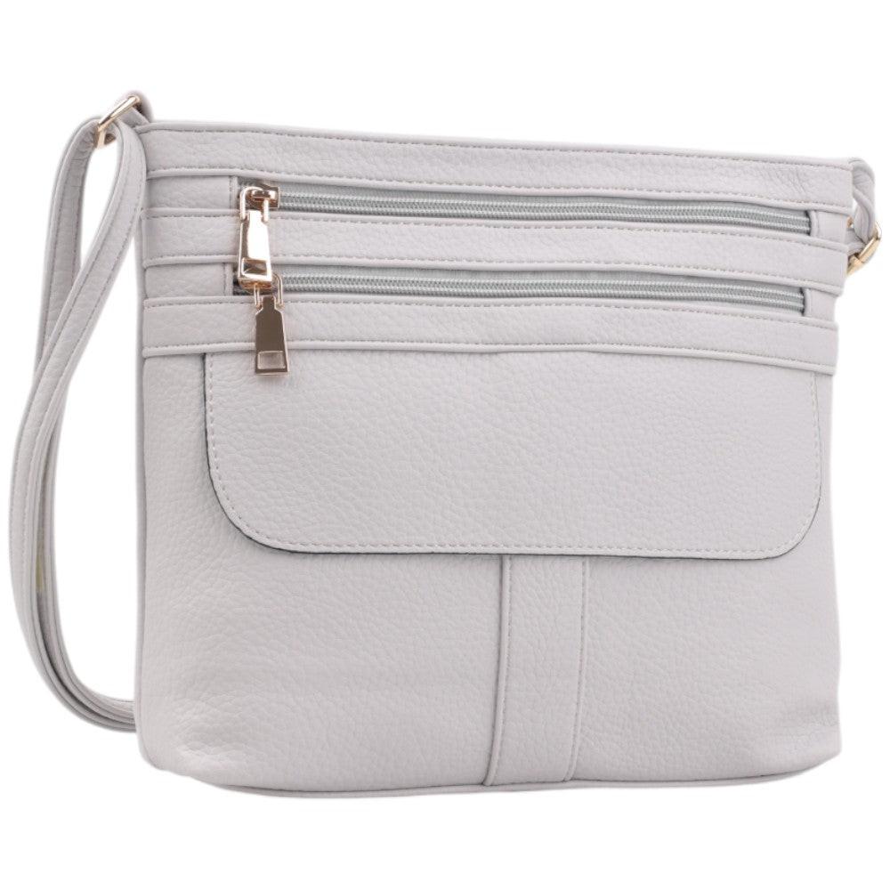 Front view of a white handbag with two zippered pockets and gold hardware.