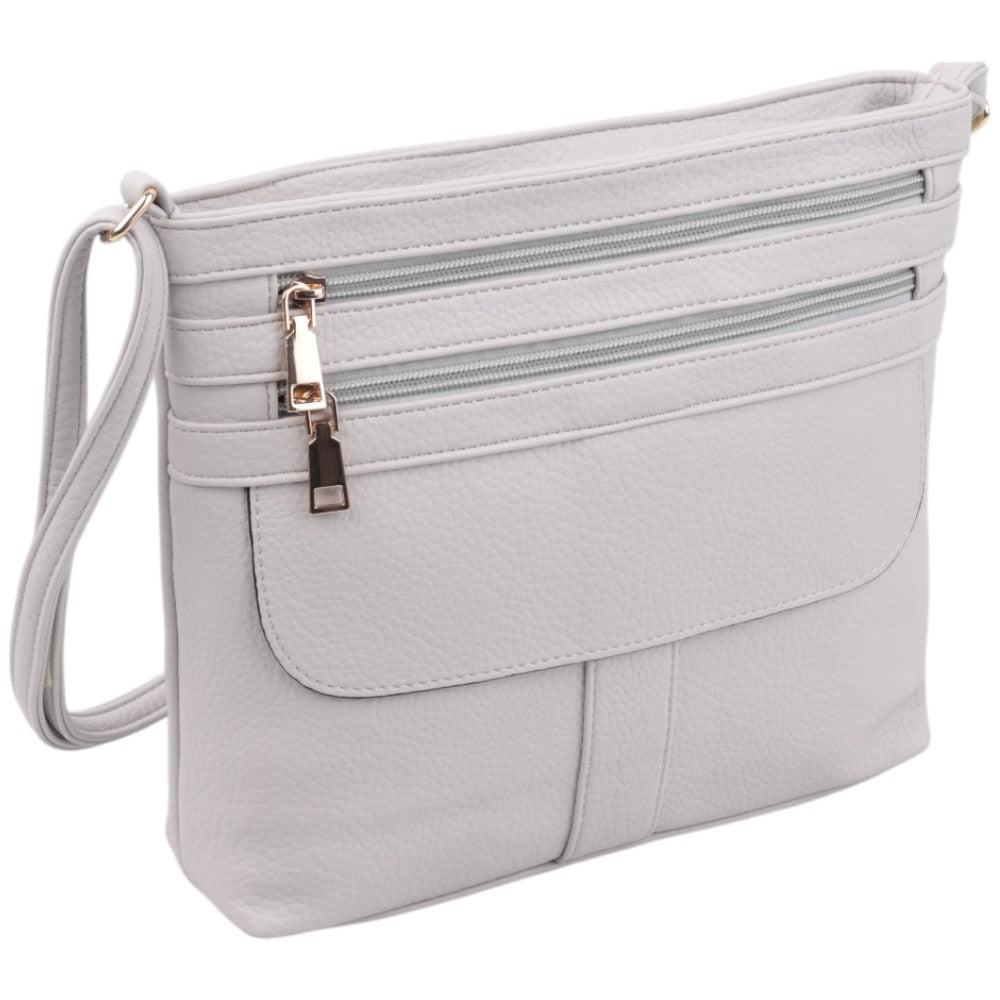 Side view of a white handbag featuring two zippered pockets and gold hardware.