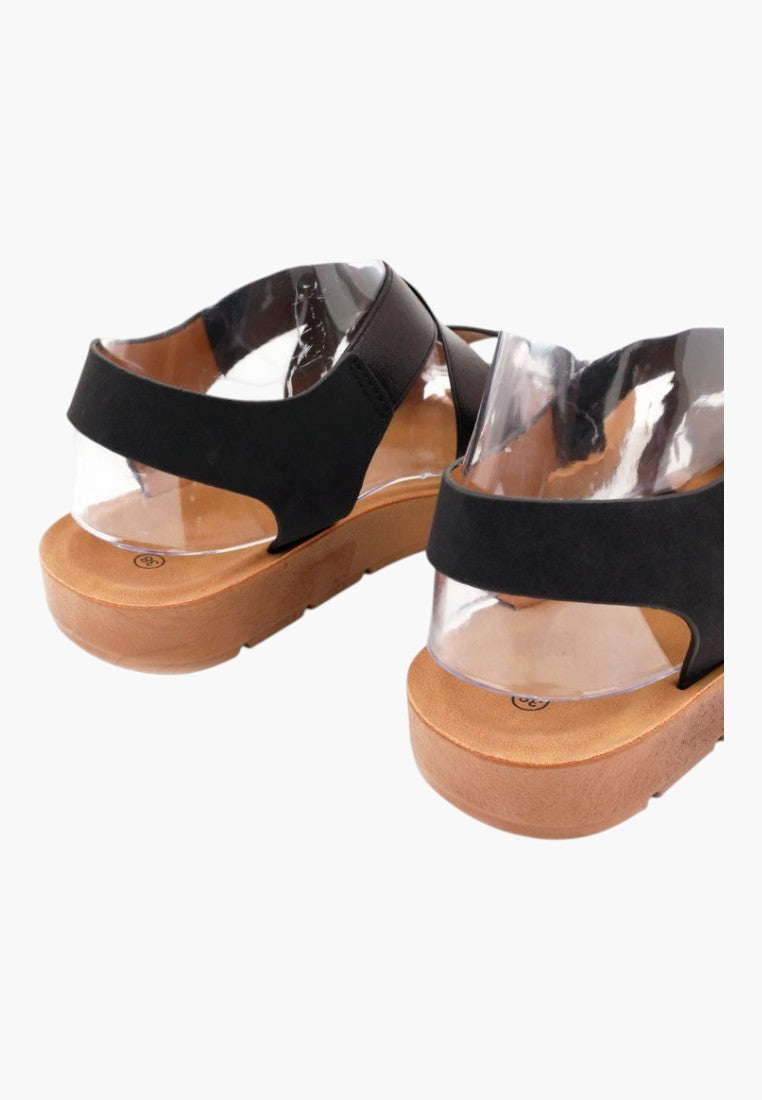 Falio black rubber and faux leather platform sandals with ankle straps and a tan sole, back view.