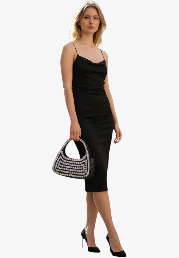 Falio black satin slip dress with cowl neck and embellished handbag, worn by a model on a city street.