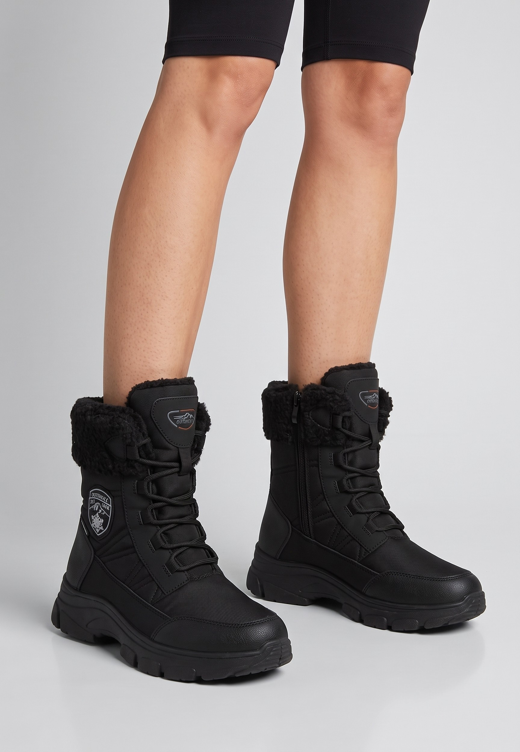 Falio women's black softshell snow boots with faux fur collar, lace-up front, side zipper, and trekking sole.