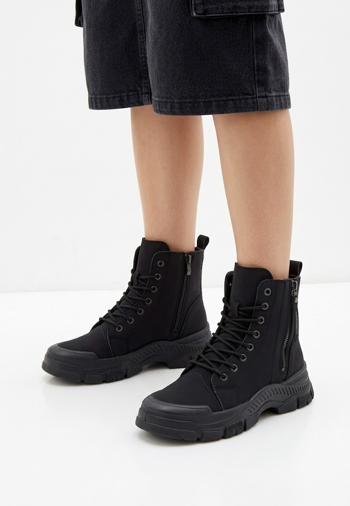 Falio black synthetic nubuck lace-up ankle boots with chunky lug soles and side zippers worn with dark shorts