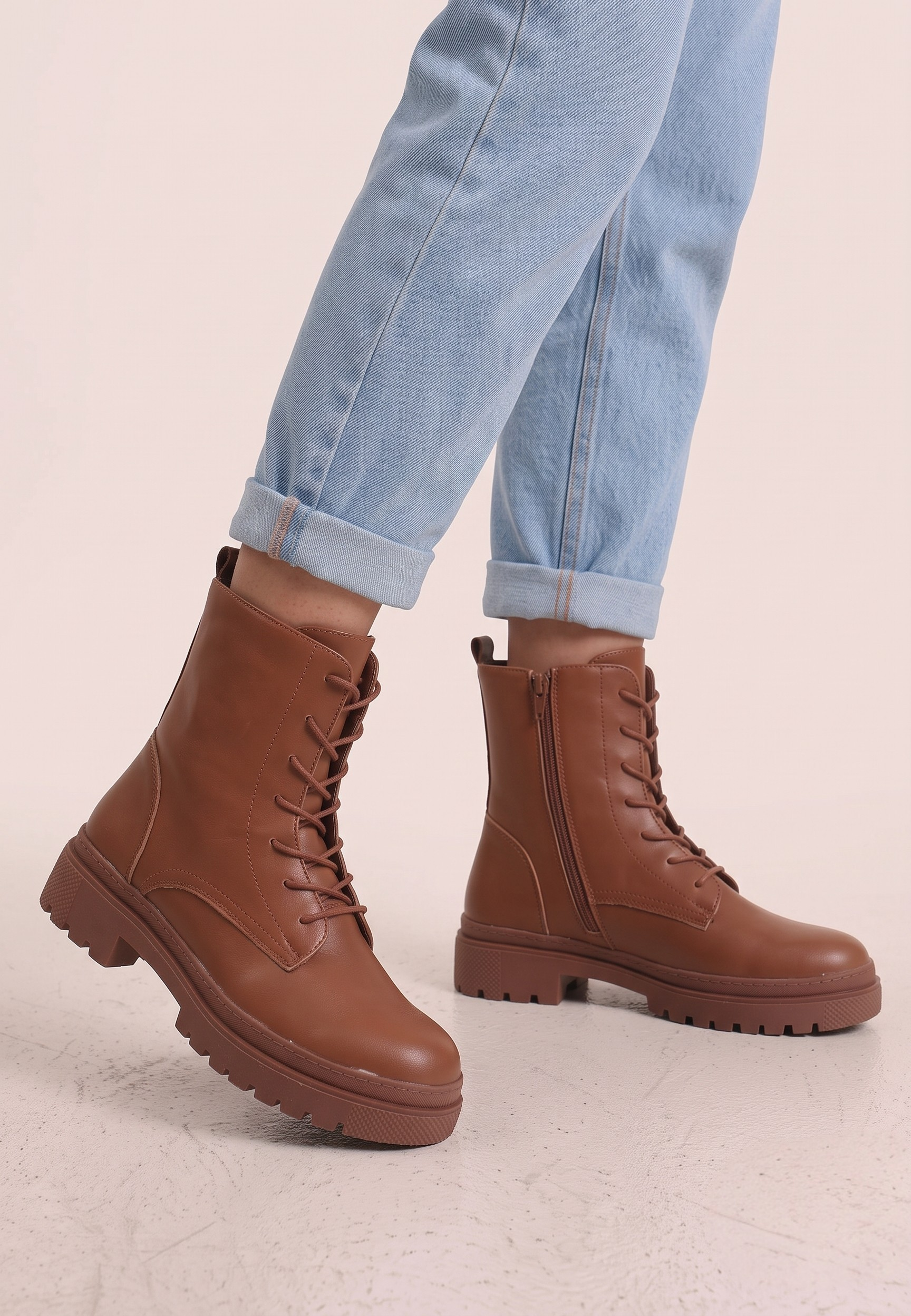 Falio brown faux leather ankle boots with lace-up closure and chunky lug soles worn with light blue jeans