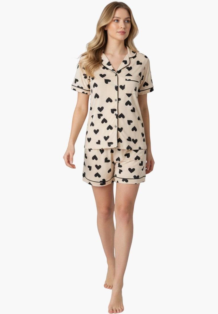 Falio women's short pajama set in cream with black heart print, short sleeves, button-up top, and shorts.
