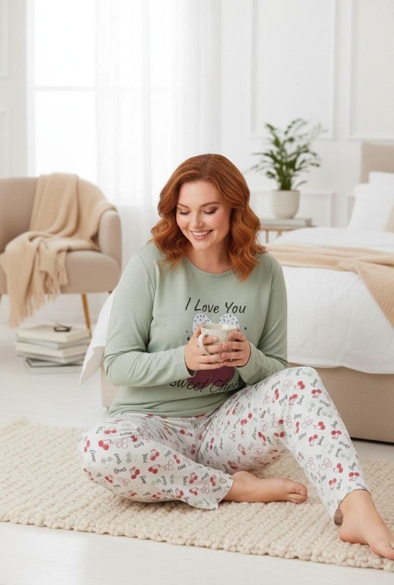 Falio women's plus size long-sleeve pajama set in light green with a cherry and bow graphic. The pants have a white base with a repeating cherry pattern.