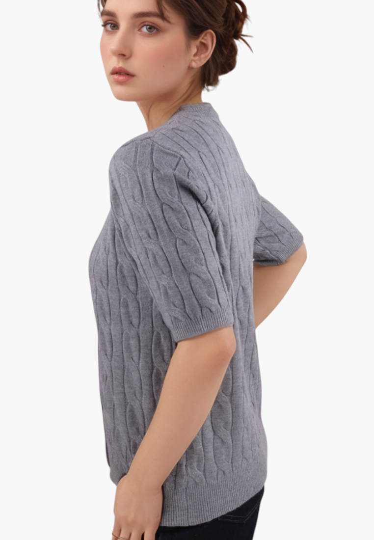 Falio grey cable-knit short-sleeve sweater worn by a woman, featuring a round neckline and soft viscose blend fabric.