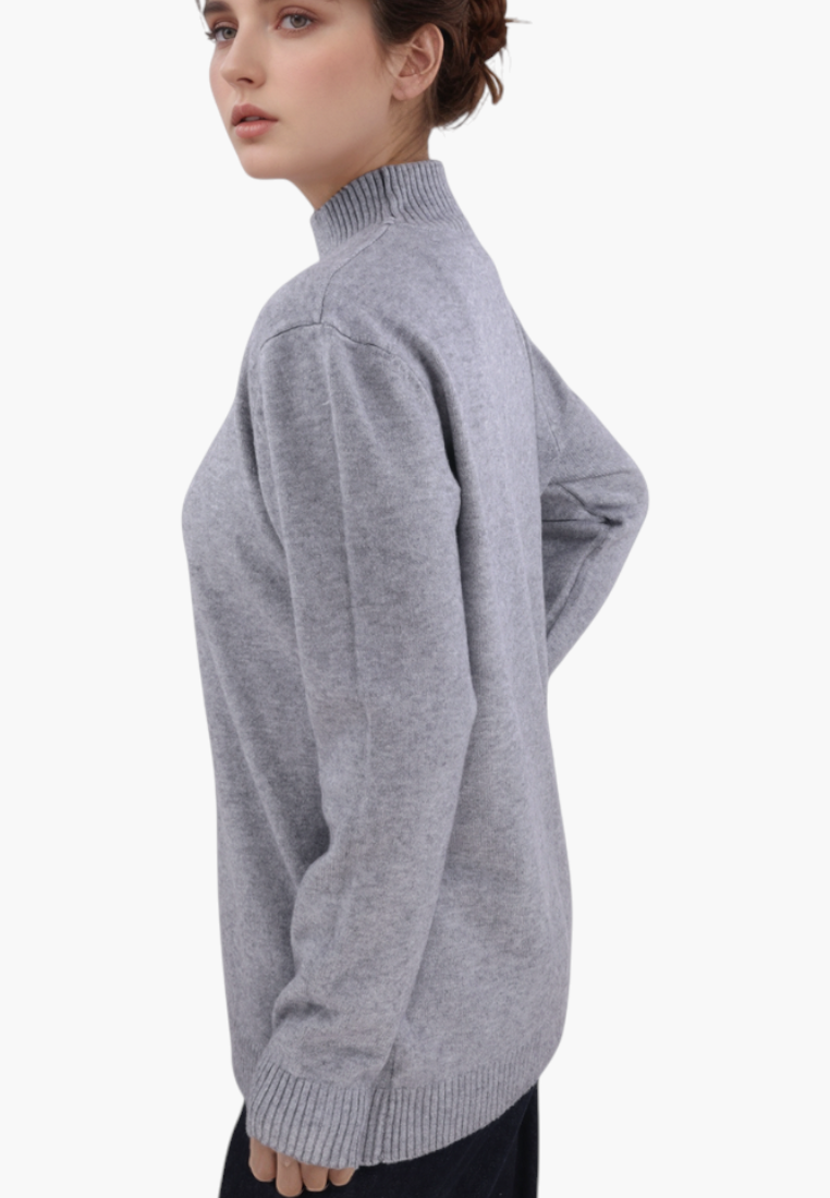 Falio grey plus size sweater with a mock neck and long sleeves worn by a model in a side profile view