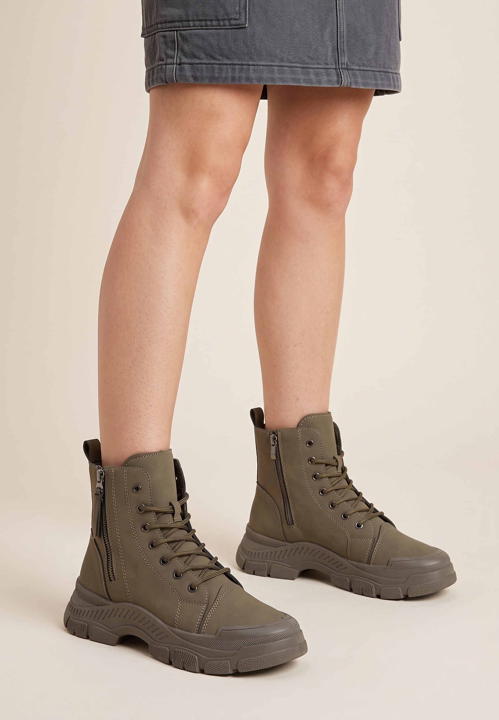 Falio olive green synthetic nubuck lace-up ankle boots with chunky lug soles worn with a grey denim skirt