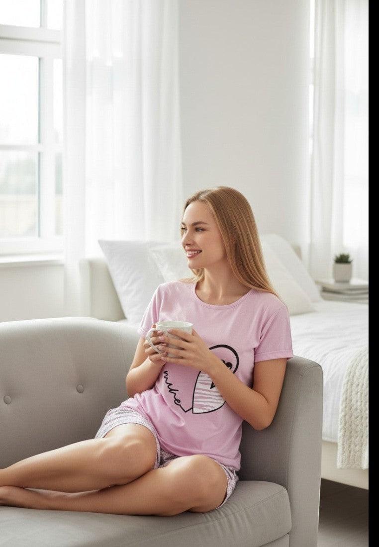 Falio pink cotton pajama set with short sleeves and heart print shorts. Features a round neckline and a graphic heart design with text.
