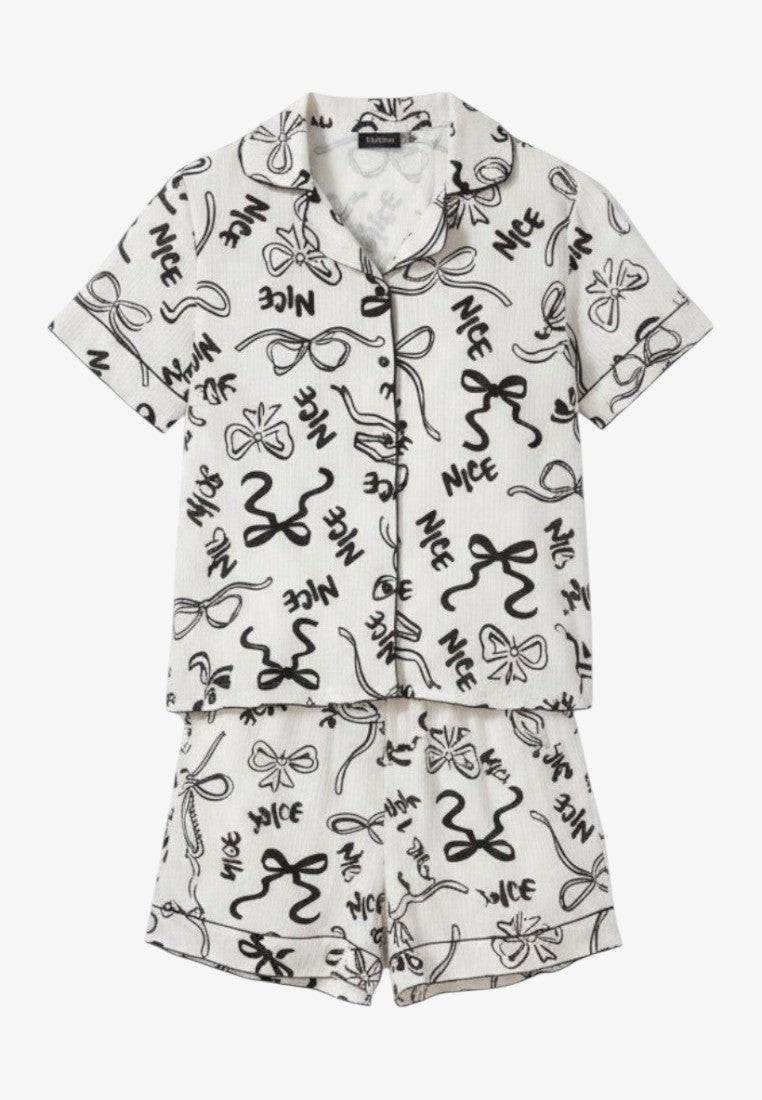 Falio white cotton pajama set with black bow and 'NICE' print. Short-sleeved collared top and shorts.
