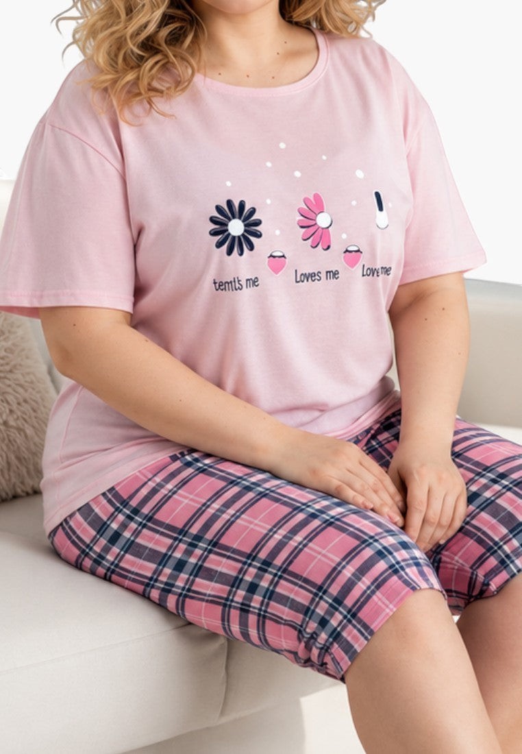 Falio women's cotton pajama set with a pink floral print t-shirt and plaid capri pants, worn by a smiling woman.
