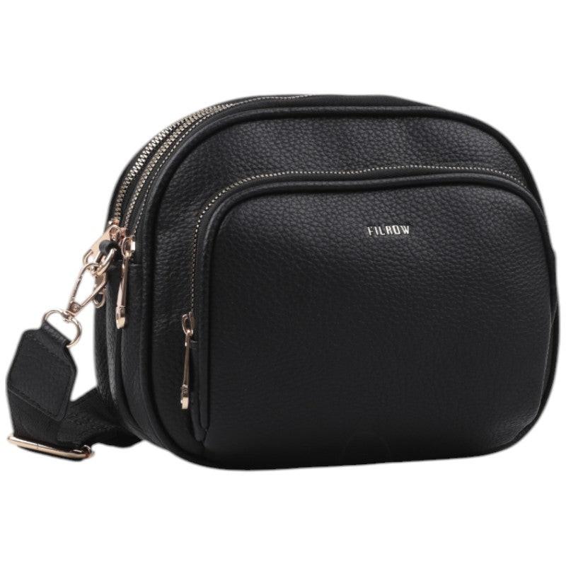 Front view of a black crossbody bag with zipper closure and gold hardware.