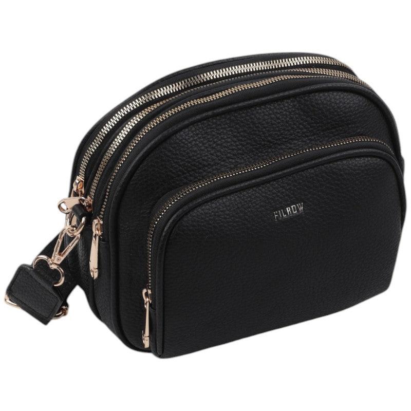 Side view of a black crossbody bag featuring multiple compartments and gold hardware.