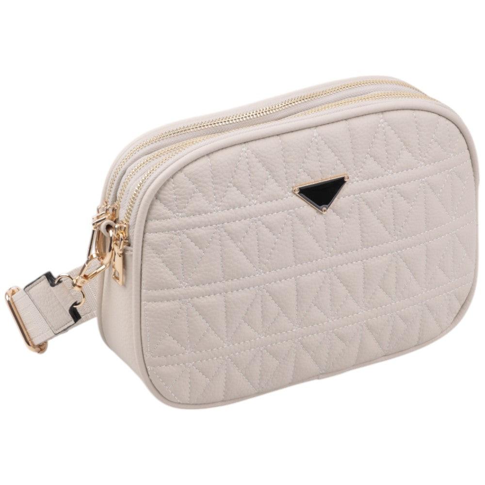 Side view of a cream crossbody bag featuring quilted texture and gold hardware.