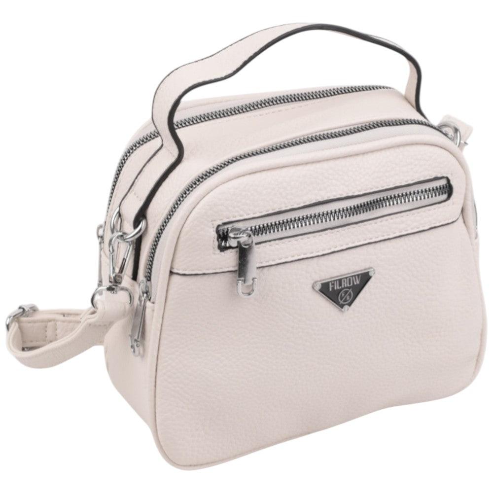 Side view of a light pink handbag featuring a zipper closure and silver hardware.
