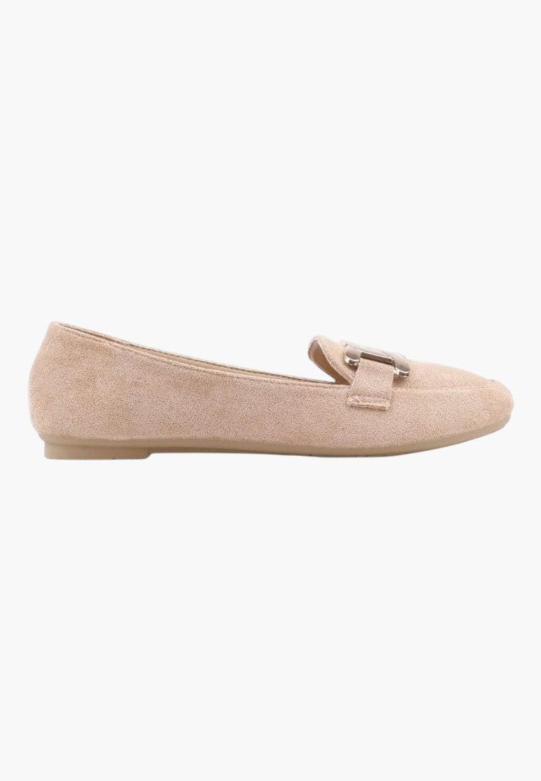 Front view of beige suede loafers featuring a flat sole and decorative buckle.