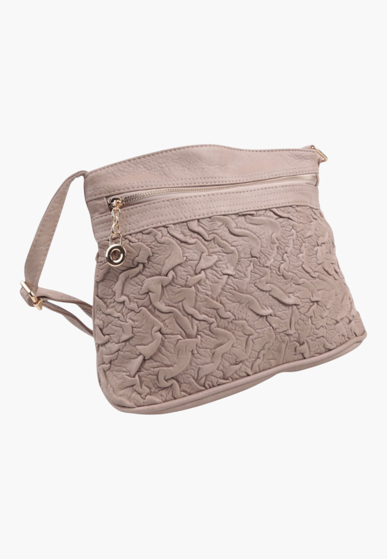 Detail close-up of a beige handbag with textured surface and zipper closure.