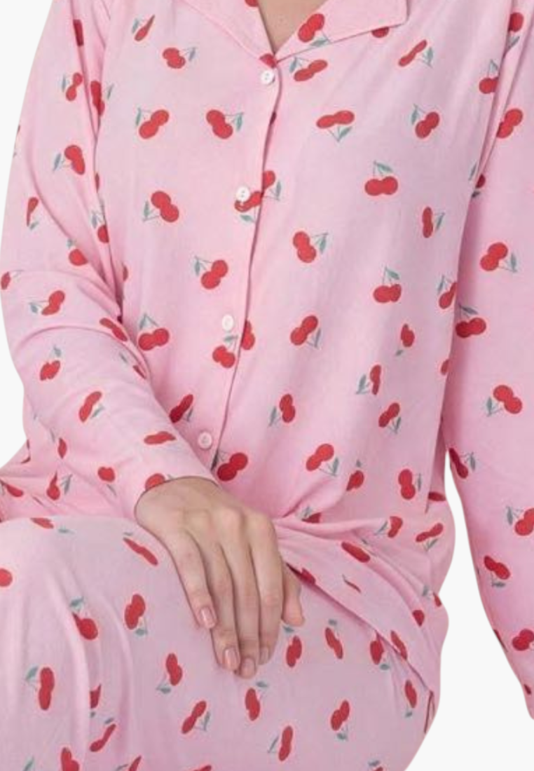 Detail close-up of a pink pajama top with strawberry print and button closure.