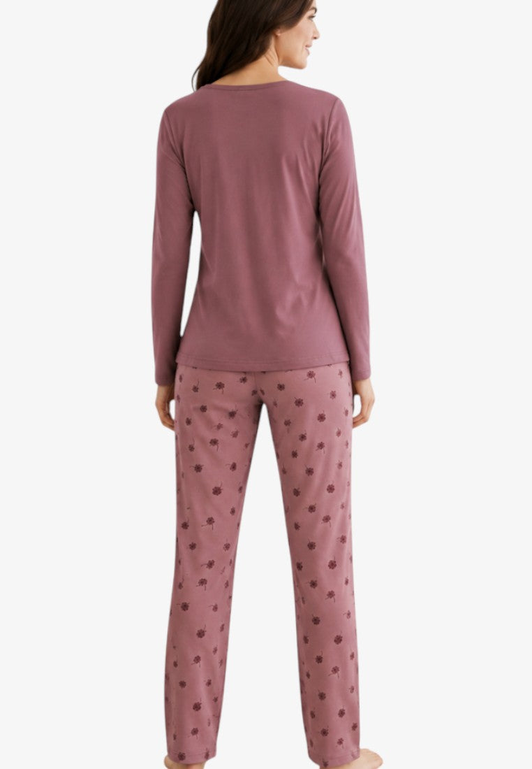 Back view of a woman in mauve insulated cotton pajamas with floral trousers.