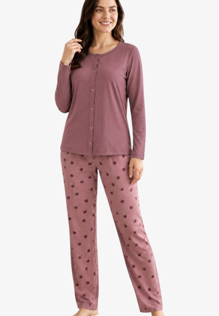 Lifestyle shot of mauve cotton pajamas featuring a long-sleeve top and floral print trousers.