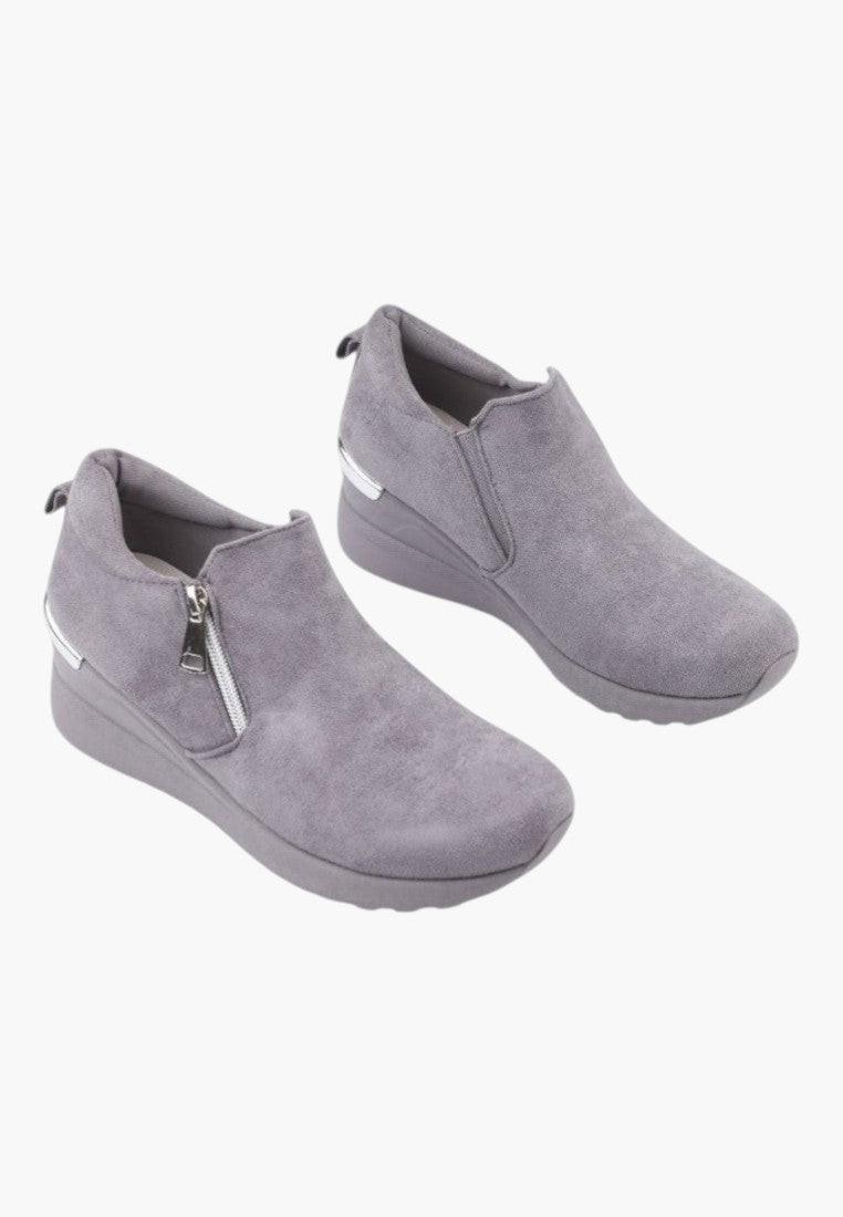 Lifestyle shot of gray eco-suede women's sneakers on a white background.