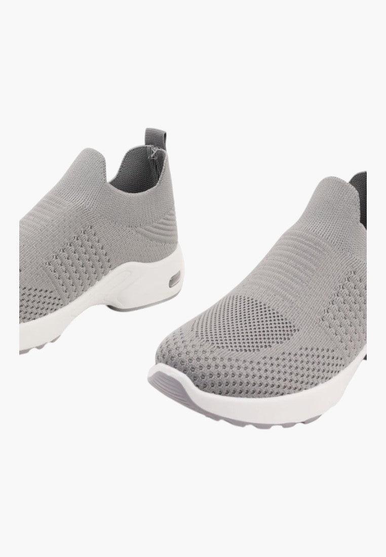 Widok z boku szarych wsuwanych sneakersów z tekstylnego materiału