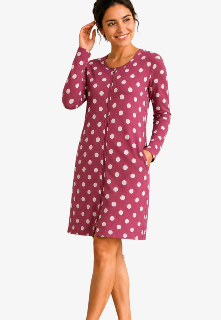 Lifestyle shot of a burgundy cotton robe with white polka dots, featuring pockets.