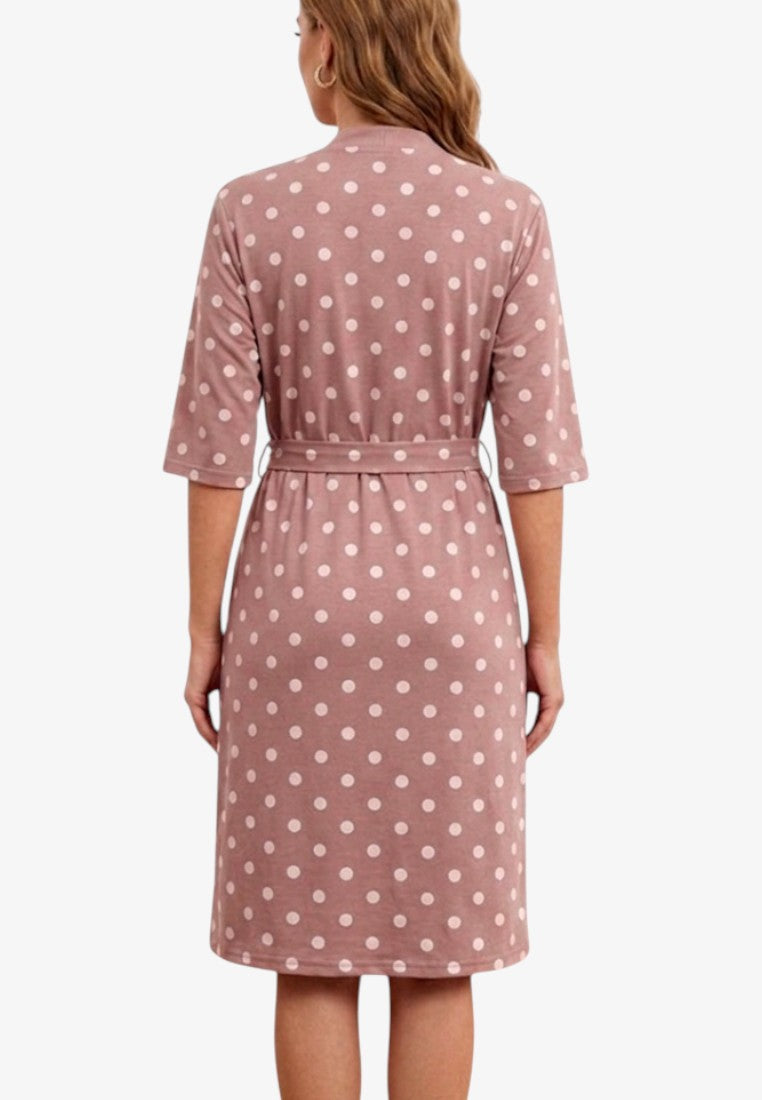 Back view of a dusty pink cotton dressing gown with white polka dots and a tie waist.