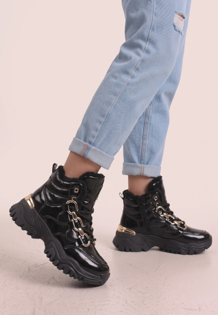 Falio black patent leather ankle sneakers with chain detail and thick flat sole worn with light blue jeans