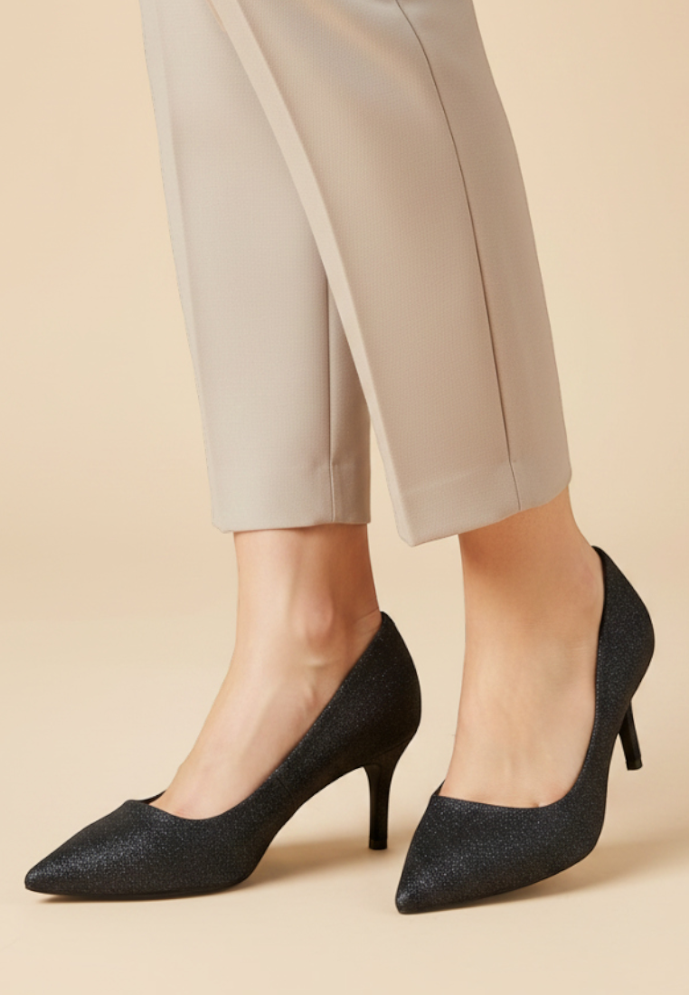 Falio black pointed-toe stiletto pumps with a shimmering finish worn with beige trousers