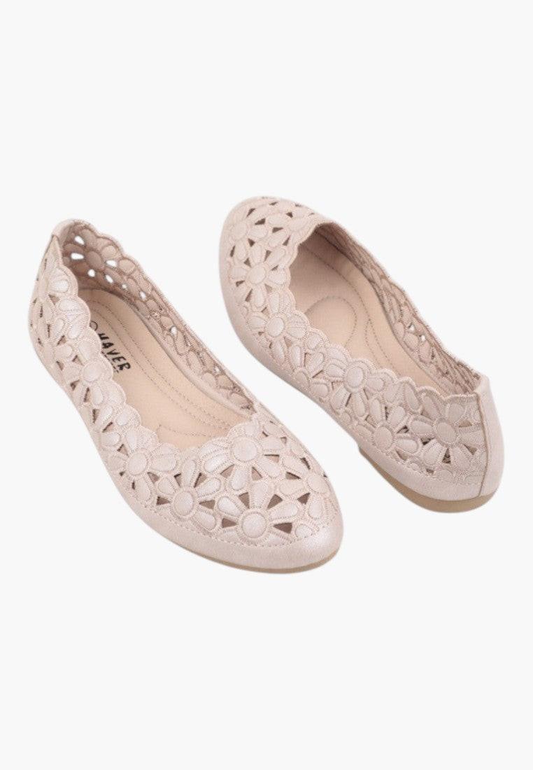 Lifestyle shot of beige ballet flats with a rounded toe and cut-out design.