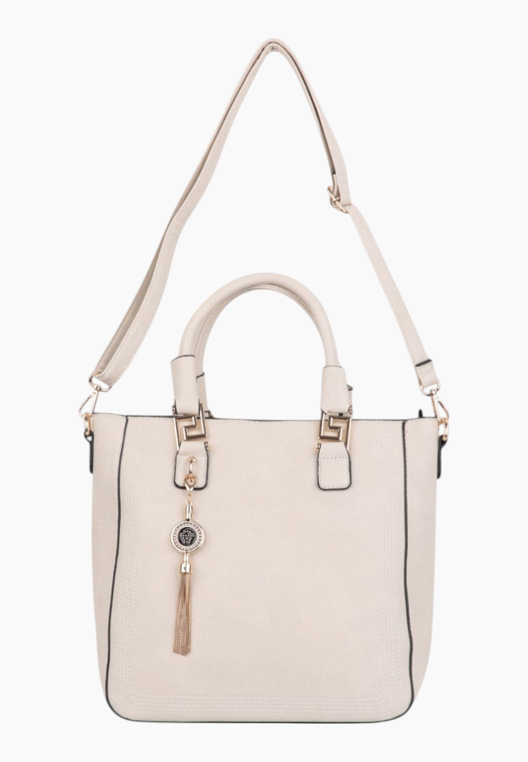 Back view of a cream handbag with logo detail and tassel charm.