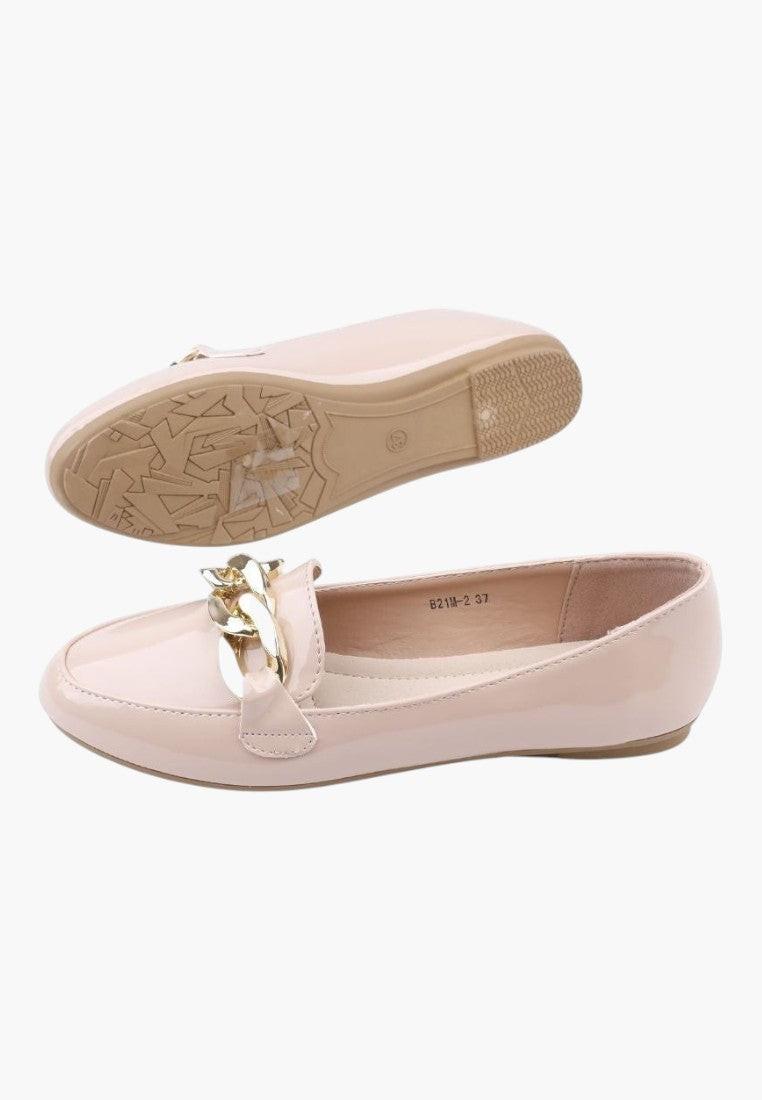 Bottom view of beige ballet flats showing textured sole on a white background
