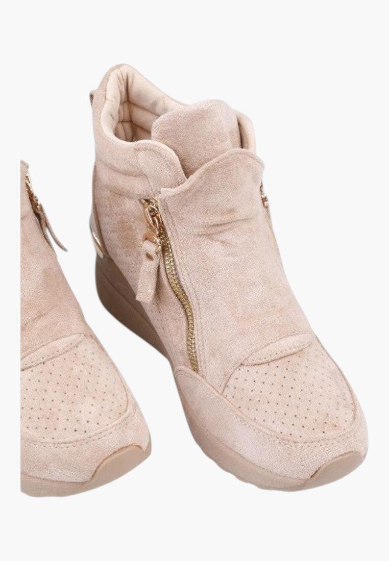 Close-up detail of beige wedge sneakers highlighting faux fur trim on a white background