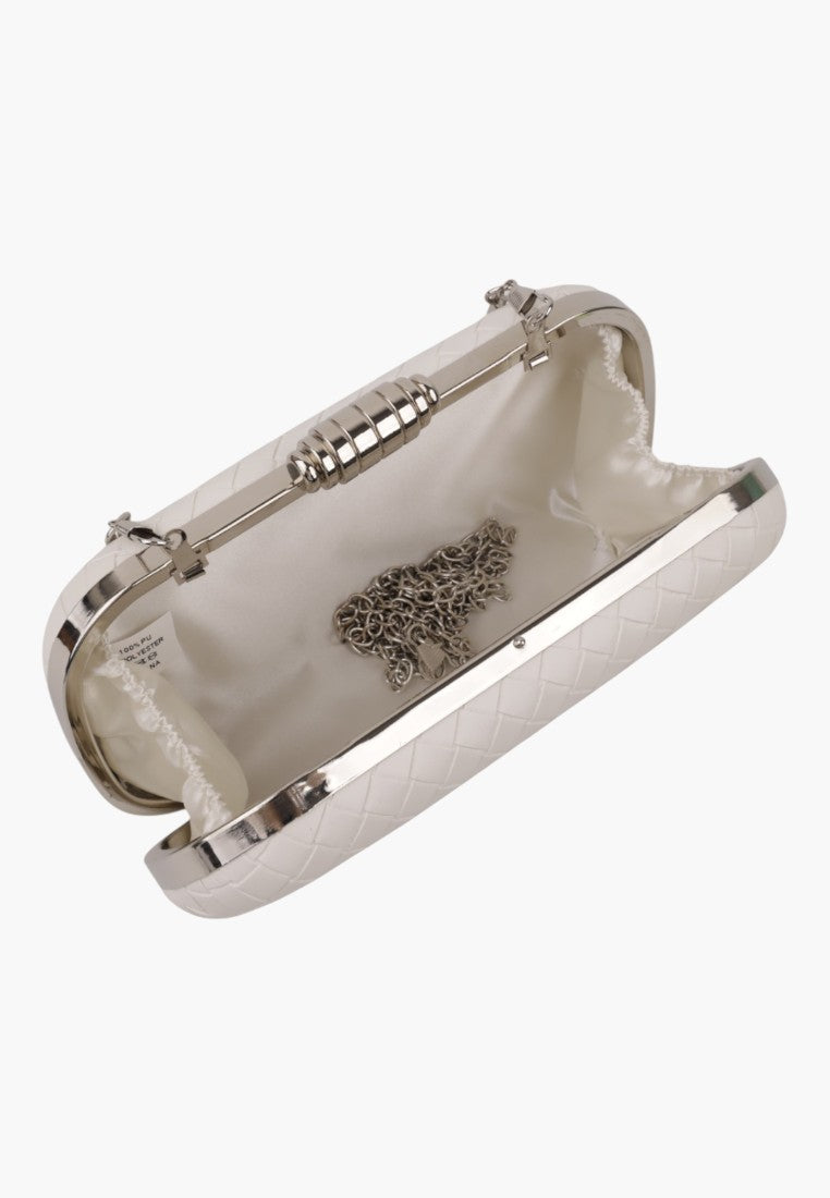Detail view of a beige handbag with a metallic clasp and interior pocket on a white background