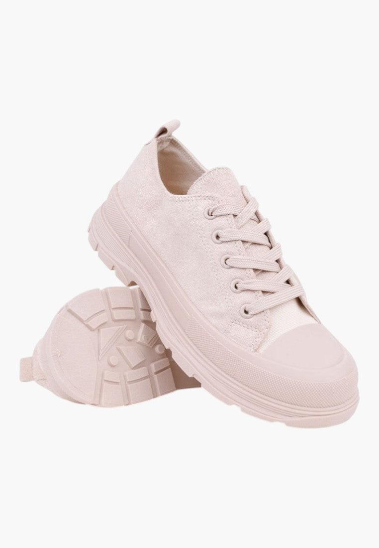 Detail of beige lace-up sneakers with thick sole on a white background