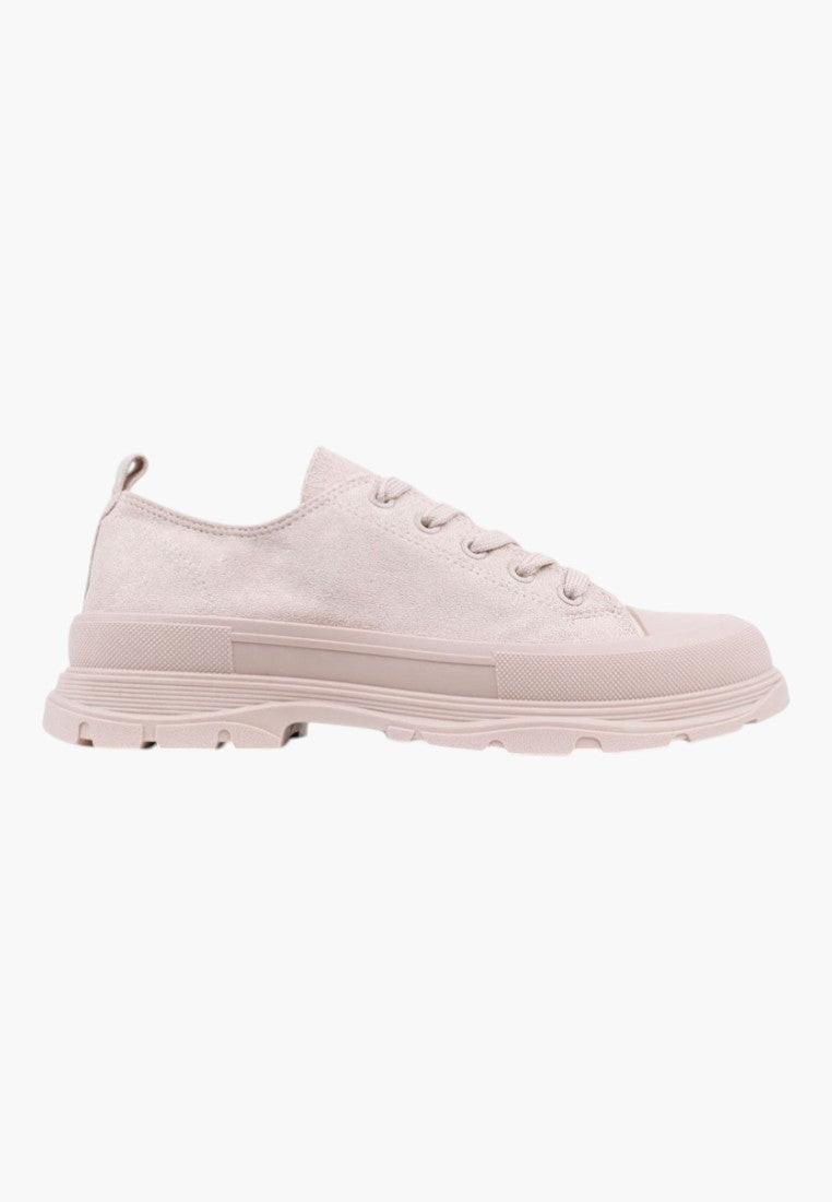 Lifestyle shot of beige lace-up sneakers showcasing casual style on a white background