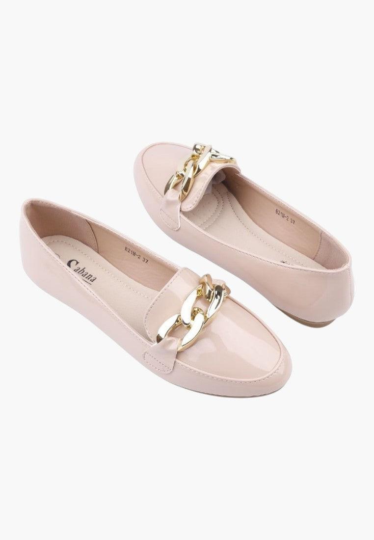 Close-up detail of beige loafers highlighting gold hardware on a white background